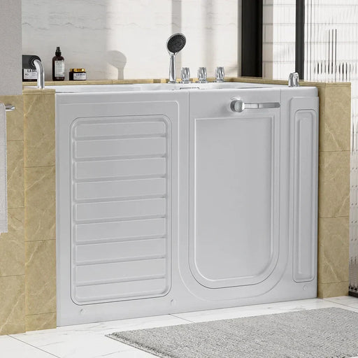White walk-in bathtub with safety door, mounted between beige marble-style tiles, with showerhead and bathroom products nearby.