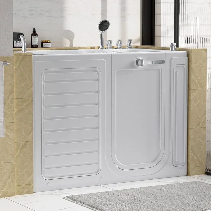 White walk-in bathtub with safety door, mounted between beige marble-style tiles, with showerhead and bathroom products nearby.