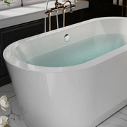 Modern white freestanding bathtub filled with pale blue water, vintage brass faucet, marble floor with white flower in foreground.
