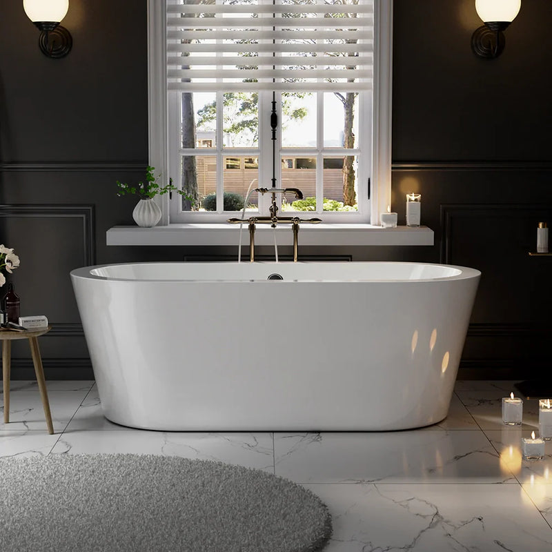 Modern white freestanding bathtub beneath a window with blinds, surrounded by dark walls, marble floor, and soft candlelight.