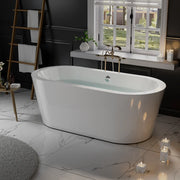 Modern white freestanding bathtub with water, positioned near a sunny window on marble floor with candles and a towel ladder.
