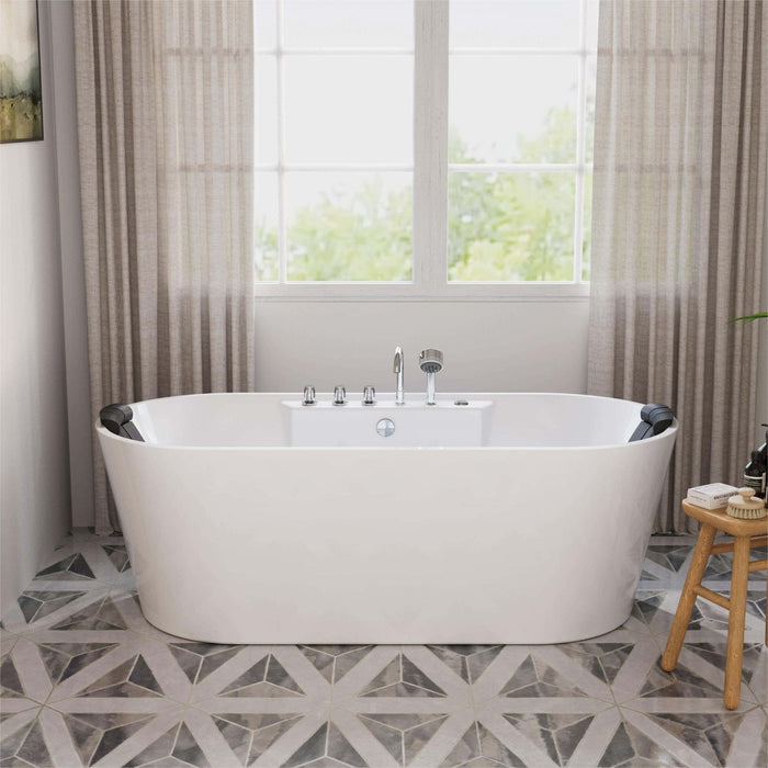 Modern white freestanding bathtub with chrome fixtures, positioned in front of sheer curtained windows with geometric tile floor and wooden stool.