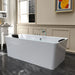 Modern white freestanding bathtub on dark marble floor, with elegant molded wall panels and a colorful abstract artwork in the background.