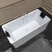 Modern white freestanding bathtub with chrome fixtures, positioned on dark marble floor against paneled beige wall, with black towels draped on sides.