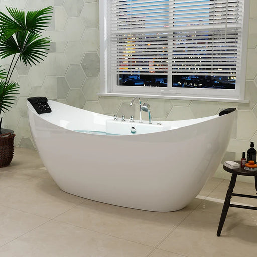 Modern white freestanding bathtub near window with blinds, hexagonal wall tiles, and green palm plant in corner