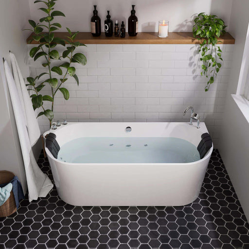 Modern bathroom with white freestanding tub, black hexagon floor tiles, and green plants on floating wooden shelf and beside tub.