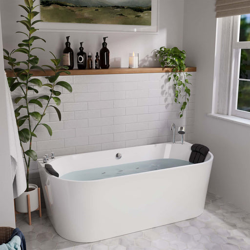 Modern white bathroom with freestanding tub, subway tile wall, wooden shelf with black bottles, and hanging green plants creating a spa-like atmosphere.