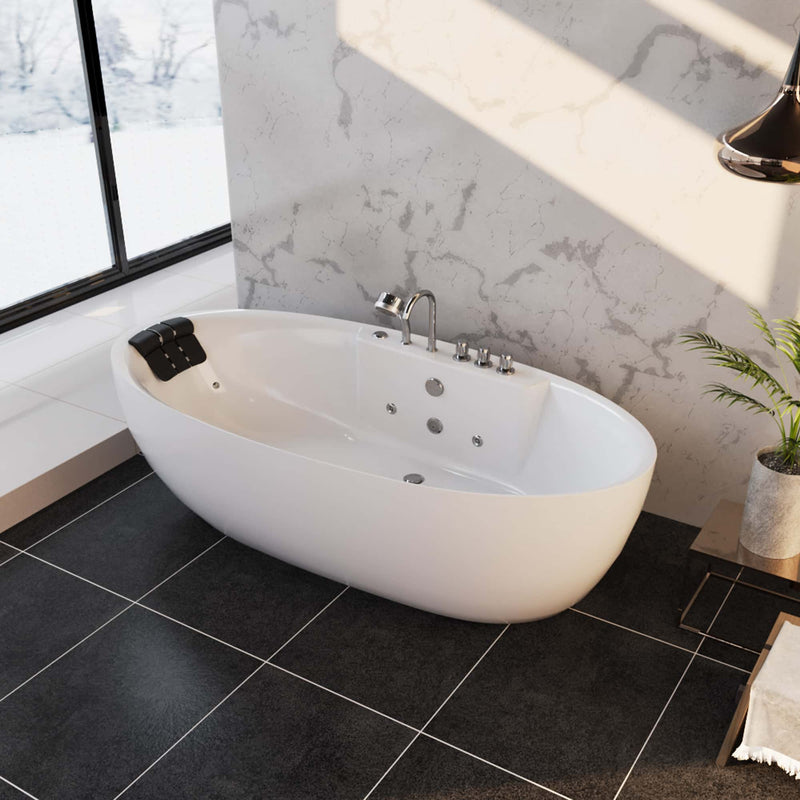 Modern white freestanding bathtub with chrome fixtures, situated on dark tile floor beside a large window with snowy landscape outside.