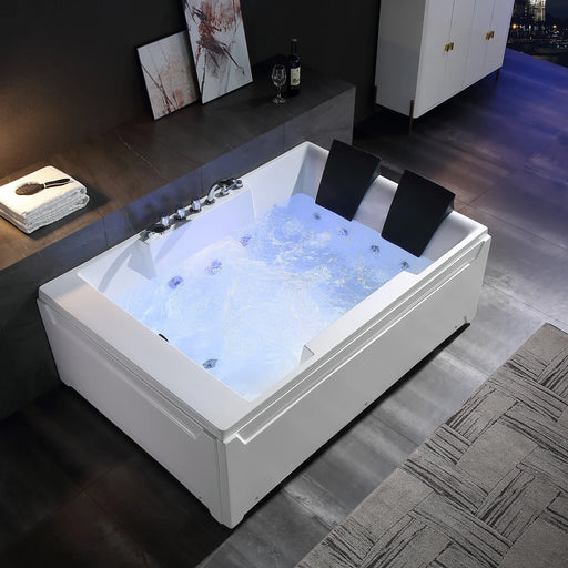 Modern white jacuzzi tub with blue-lit bubbling water, black headrests, and chrome fixtures in a sleek bathroom setting.