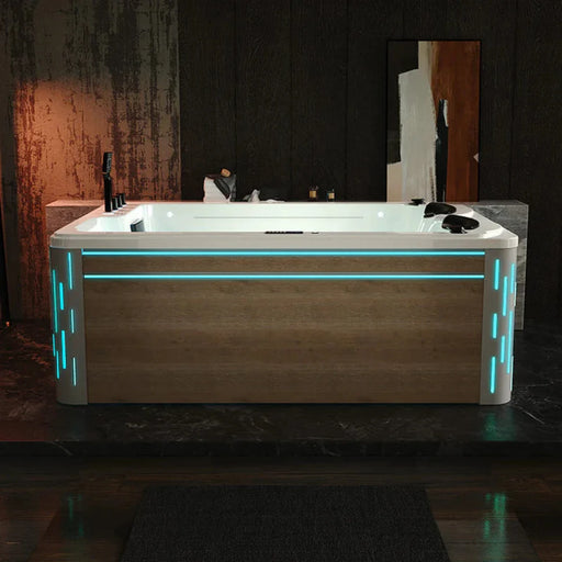 Modern white bathtub with blue LED accent lighting, set against a textured dark background with dramatic mood lighting.