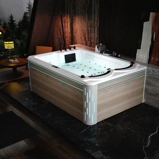 Modern hot tub with white interior and wood panel exterior, illuminated by soft blue LED lighting in a dimly lit rustic room with trees visible in background.