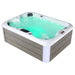 Hot tub filled with turquoise water, featuring white trim and gray wooden side panels, with illuminated jets and digital control panel.