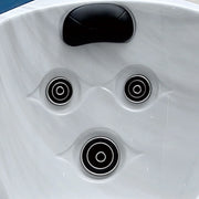 White hot tub surface with three black circular jets and a black headrest
