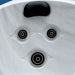White hot tub surface with three black circular jets and a black headrest