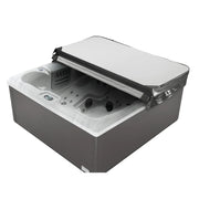 Gray and white hot tub with open cover, revealing interior jets and control panel