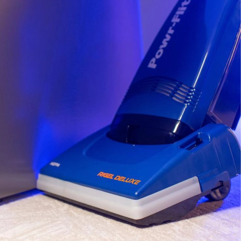 Powr Flite Rigel Deluxe Upright Vacuum w Onboard Tools PV130 W14 U person extending hose in room with lighted wall.