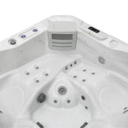 White hot tub with multiple circular jets and a gray ventilation unit in the center, viewed from above.