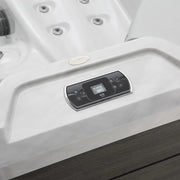 White hot tub with digital control panel, chrome-trimmed with circular jets and dark wooden border