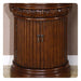 Ornate dark wood column-style cabinet with carved floral top and vertical ribbed sides, double doors with metal knobs