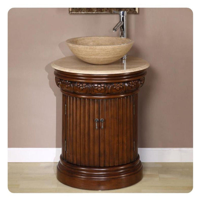 Ornate wooden bathroom vanity with carved column base, marble top, and round stone vessel sink with chrome faucet.