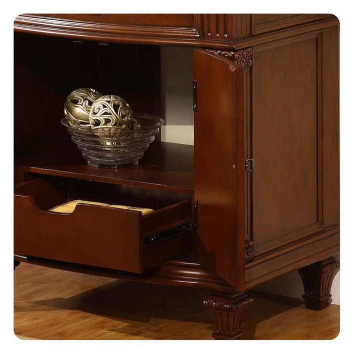 Ornate golden decorative sphere in textured glass bowl, placed on dark wooden shelf with open drawer, classic carved furniture detail visible