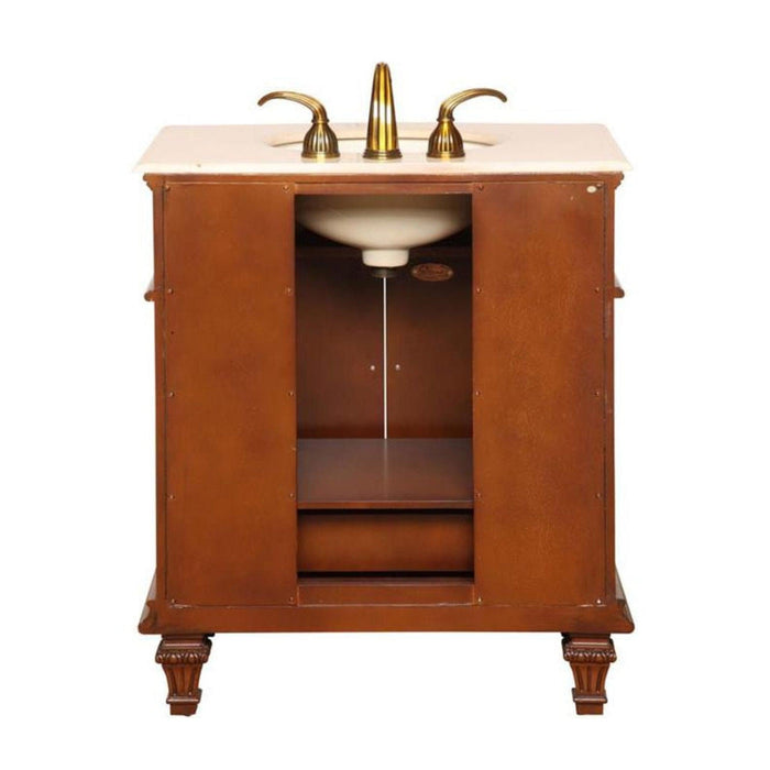 Elegant wooden bathroom vanity with marble top, brass faucet, and ornate carved legs, featuring an open storage compartment.