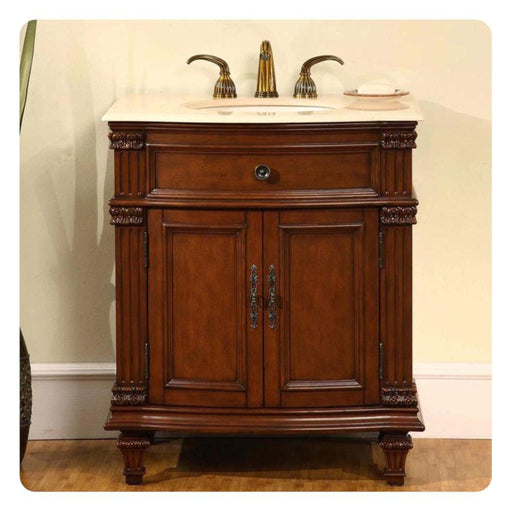 Ornate wooden bathroom vanity with marble top, curved legs, and decorative brass faucets and hardware.