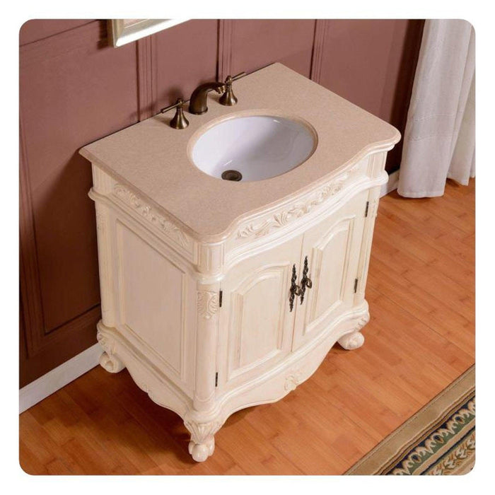 Antique white bathroom vanity with ornate carved details, curved legs, and oval white sink with bronze faucet handles.