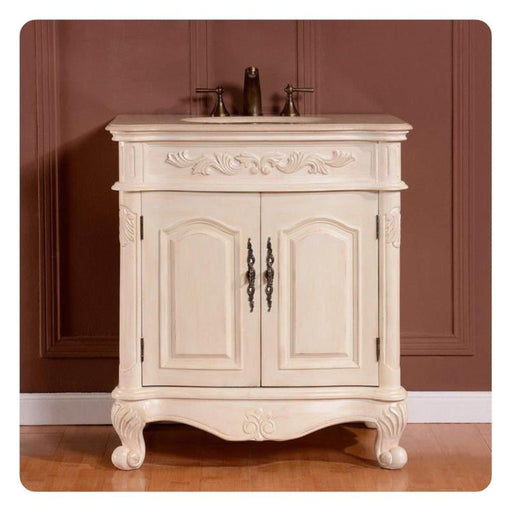 Ornate white bathroom vanity with curved legs, decorative carved details, and bronze faucet on marble top.