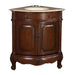 Corner bathroom vanity in rich dark wood with curved cabinet doors and ornate carved details, topped with beige marble and oval undermount sink.