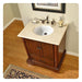 Traditional wooden bathroom vanity with white marble top, oval sink, bronze faucet, and decorative Persian rug on hardwood floor.