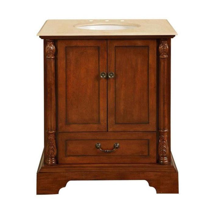 Traditional wooden bathroom vanity with rich brown finish, decorative columns, and cream marble top with oval sink.
