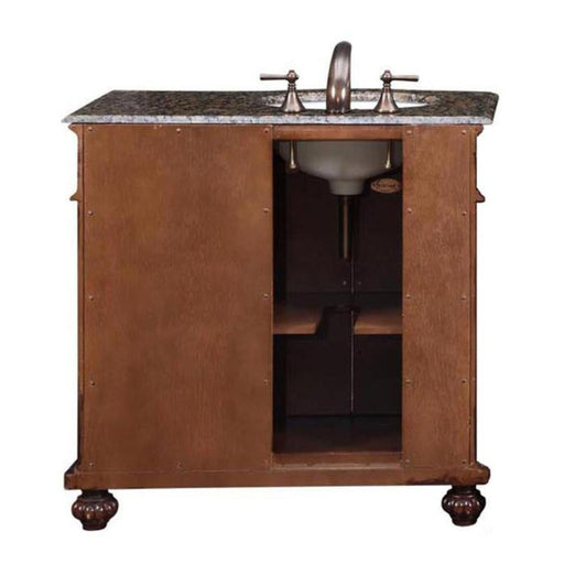 Wooden bathroom vanity with marble top, bronze faucet, and ornate ball-shaped feet, with open cabinet storage underneath.