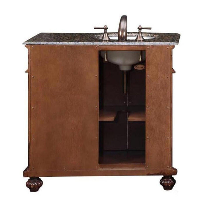 Wooden bathroom vanity with marble top, bronze faucet, and ornate ball-shaped feet, with open cabinet storage underneath.
