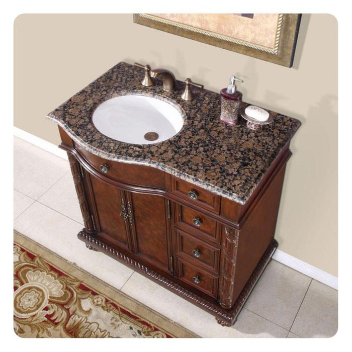 Elegant wooden bathroom vanity with curved marble top, white sink, and decorative bronze faucet fixtures, with soap dispenser and accessories.