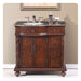 Rich mahogany bathroom vanity with granite top, ornate carved details, and two cabinet doors with three side drawers.