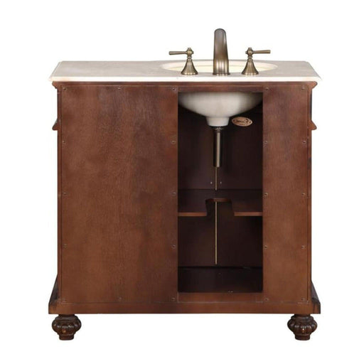 Wooden bathroom vanity with marble top, antique bronze faucet, and open storage shelf, mounted on ornate carved feet.