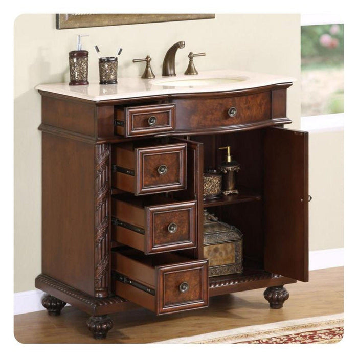 Elegant wood bathroom vanity with white marble top, antique bronze faucet, and decorative drawers open to reveal storage space.
