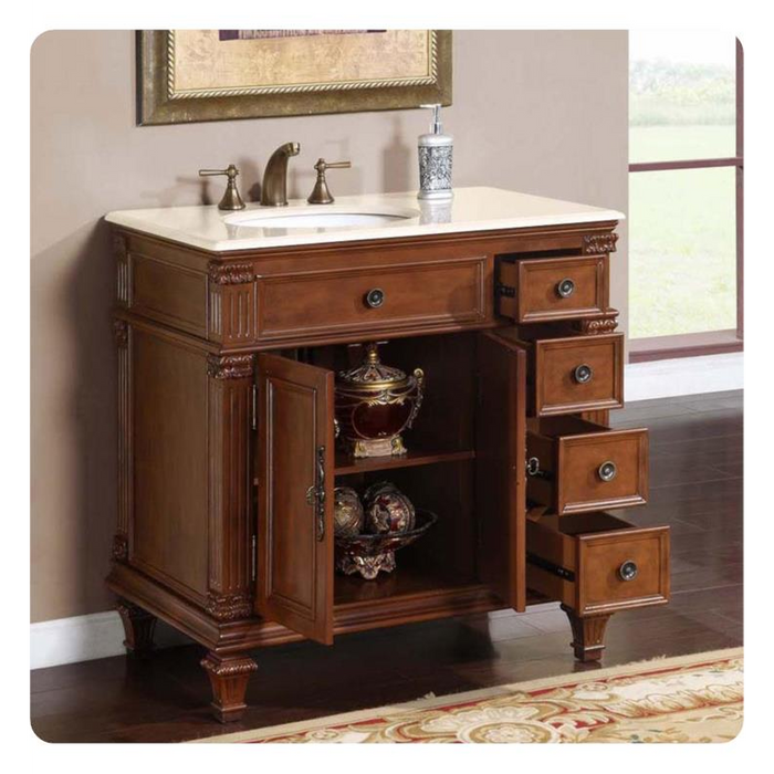 Elegant wooden bathroom vanity with white marble top, open cabinet, decorative drawers, and bronze faucet fixtures.