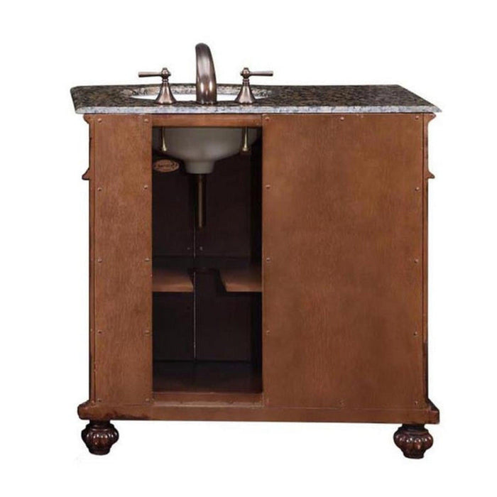Wooden bathroom vanity with granite countertop, oval sink, and bronze faucet, ornate carved feet on base