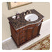 Elegant wooden bathroom vanity with granite top, white sink, and ornate soap dispensers, featuring rich brown woodwork and decorative details.
