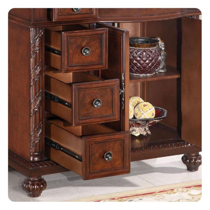 Rich mahogany side table with three staggered drawers, ornate carved details, and decorative shelving with burgundy glass candle holder and fruit.