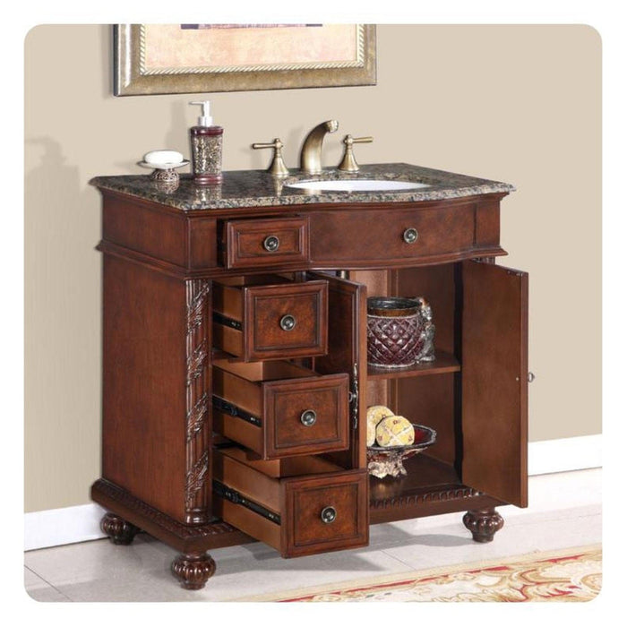 Rich mahogany bathroom vanity with marble top, multiple drawers, and ornate details, featuring a sink and decorative accessories.