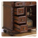 Ornate wooden side table with three open drawers, decorative carved details, and round brass drawer pulls, sitting on carved bun feet.