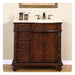 Rich mahogany bathroom vanity with marble top, decorative drawers, and antique bronze faucet and accessories.