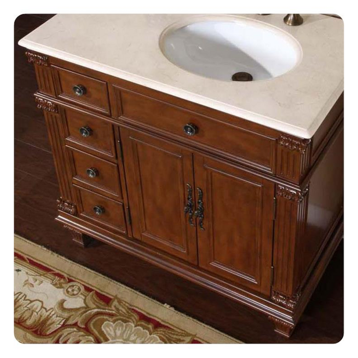 Rich wood bathroom vanity with carved details, white stone top, and oval sink.