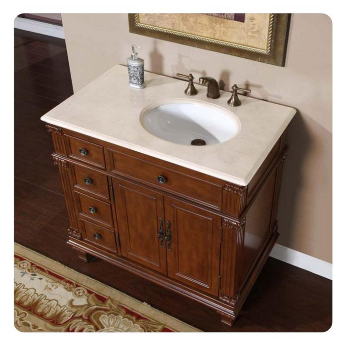 Antique-style wooden bathroom vanity with white marble top, oval sink, and ornate bronze faucet fixtures.