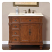 Ornate wooden bathroom vanity with four drawers, two cabinet doors, white marble top, and bronze faucet fixtures.