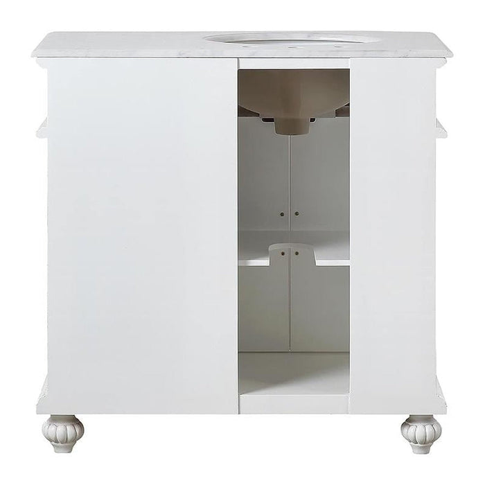 White bathroom vanity with marble top, decorative bun feet, and open center shelving section