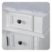 White wooden cabinet with raised panel drawers and black round knobs, marble-like top surface.